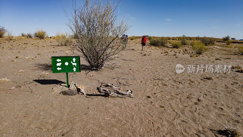 徒步旅行的人在克利普斯普林格步道奥格拉比斯国家公园(Klipspringer Trail Augrabies National Park)经过一个路标